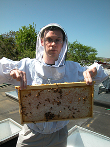 Etienne James Hunter Pollard holds honey frame